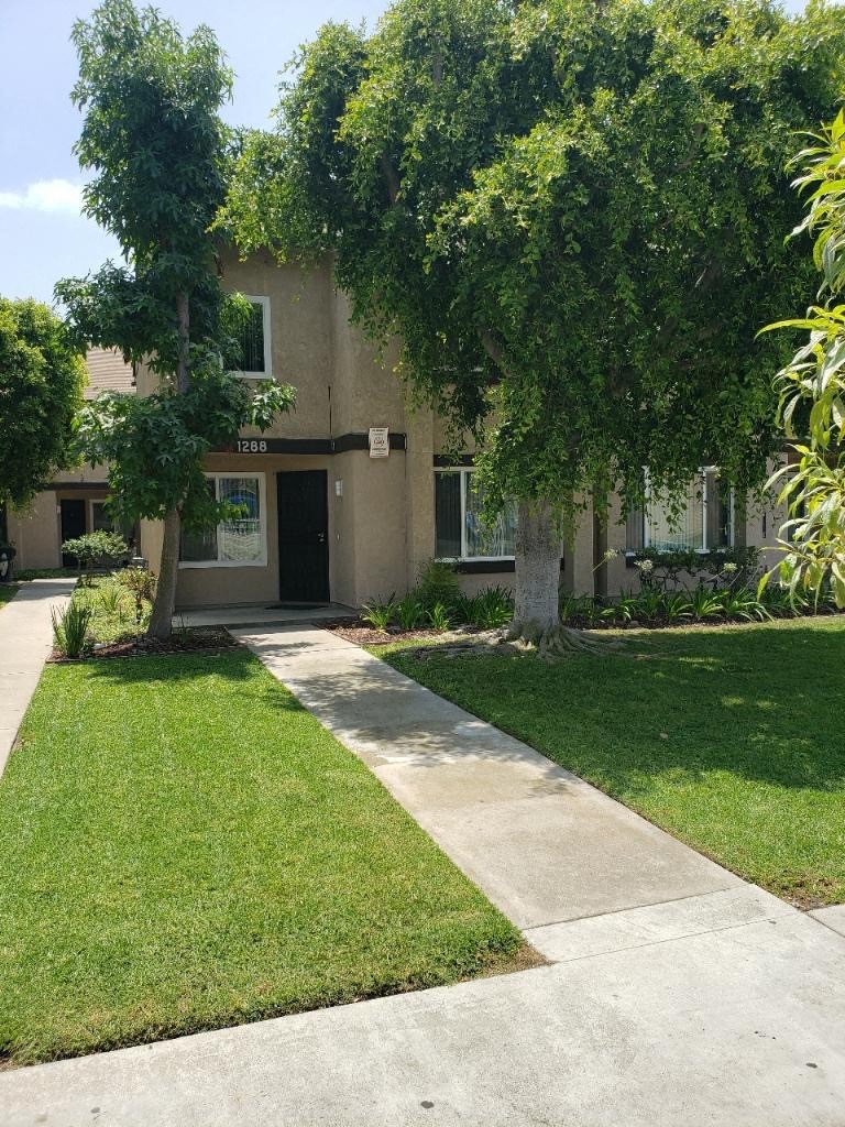 a house with a lawn and trees in front of it